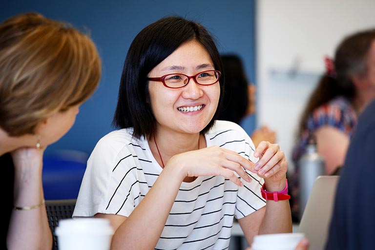 A faculty member speaks to two others.