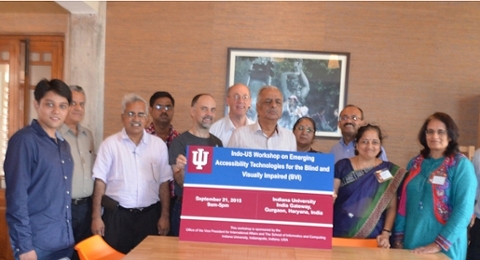 Group of people standing in front of a sign.