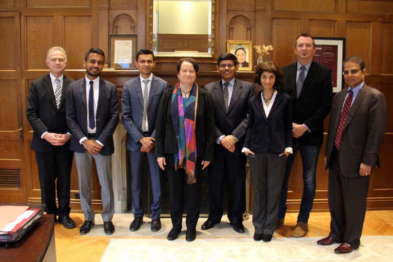 Provost Robel standing with a group of people in front of a fireplace.