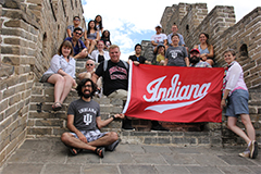 Students with an IU flag standing at the great wall of China.
